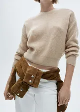 Sweater color beige de lana con cuello redondo y mangas largas.