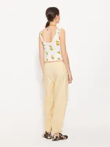 Pantalón cargo color amarillo claro, confeccionado en poplin asargado. Tiene cuatro bolsillos plaqué con refuerzos triangulares en hilo crudo. El ruedo lleva jareta para ajustar y abuchonar con lazo.