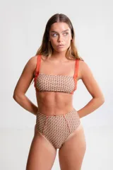 Bombacha de bikini de tiro alto, estilo semivedetina, con estampado geométrico en tonos marrones y beige, y tiras laterales color naranja.