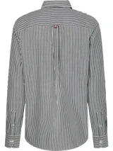 Camisa Tommy Hilfiger de corte relaxed, con estampado de rayas verticales blancas y negras, cierre con botones y logo bordado en el pecho.