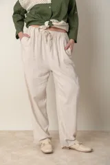Pantalón italiano de lino color beige, de corte recto, con cintura elastizada y cordón ajustable. Presenta bolsillos laterales.