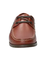 Zapato náutico de cuero marrón con cordones negros, suela de goma y detalle de logo de pato bordado en el lateral.