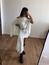 Blusa corta blanca con escote off-shoulder y mangas anchas.