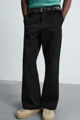 Pantalón negro de corte recto con bordados florales a tono, bolsillos laterales y traseros de vivo. Cierre frontal con cremallera y botón.