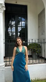 Vestido largo negro con escote en V, cut outs laterales bajo el busto y breteles finos cruzados y atados en la espalda.