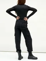 Pantalón negro de corte holgado con cintura elástica ajustable con cordón, bolsillos laterales y bolsillos tipo cargo en los laterales de las piernas.