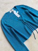 Top de punto manga larga, color azul brillante, con escote en V y cierre frontal con cordones.