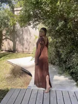 Vestido largo marrón de tejido de algodón fino y ligero, con mangas largas y escote redondo. Puede usarse con el escote hacia adelante o hacia atrás.