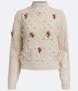 Suéter de punto color crema con cuello alto, textura de pompones y bordados florales.