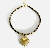 Gargantilla con cordón estampado animal print y dijes dorados con diferentes motivos: concha, sol, corazón, golondrina, pez y palmera.