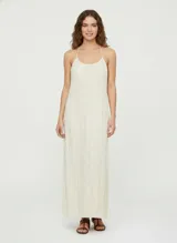 Vestido largo color crema con textura arrugada, escote redondo y breteles finos ajustables.