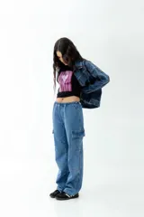Pantalón cargo de jean celeste con lavado esfumado, tiro bajo, pierna ancha y bolsillos cargo.