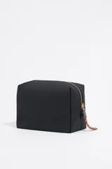 Neceser negro de nylon con logo dorado de Bimba y Lola, cierre con cremallera dorada y tirador con pieza de piel y cordón multicolor. Incluye bolsillo interior.
