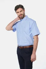 Camisa celeste a rayas verticales, de manga corta, con cuello abotonado, bolsillo en el pecho y logo bordado.