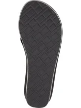 Ojotas de mujer con plataforma tipo cuña de color negro. Las tiras son de textil negro con una cinta decorativa que lleva el texto "HILFIGER" y el logo de Tommy Hilfiger en blanco y dorado. La plantilla lleva el logo de Tommy Hilfiger impreso.