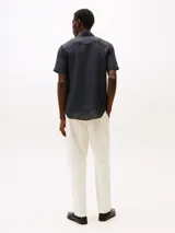 Camisa de manga corta azul marino de lino con corte regular, cuello con botones y logo de Tommy Hilfiger bordado en el pecho.