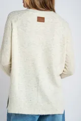 Sweater color beige de tejido texturado, con cuello redondo y mangas largas.