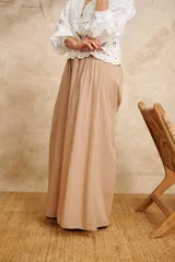 Pantalón palazzo color beige, de algodón, con cintura elastizada y corte amplio.