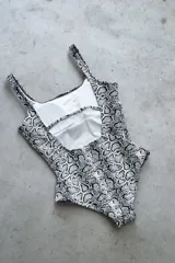 Traje de baño enterizo color dorado con textura brillante, escote recto, tiras anchas y espalda cuadrada.