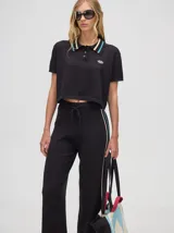 Pantalón de algodón negro, corte holgado y pierna ancha con pretina elástica. Presenta rayas bicolor al costado en blanco y celeste. Calce de tiro alto.