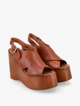 Sandalia negra con plataforma de madera y tira trasera ajustable con hebilla.