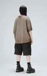 Remera de manga corta con calce extra oversize, color marrón chocolate con efecto gastado/deslavado. Presenta un corte con recortes horizontales en el frente y la espalda, y cuello redondo con terminación deshilachada.