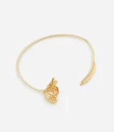 Gargantilla tipo choker de metal con baño dorado, de diseño rígido y abierto con una flor y un pétalo detallados en los extremos. Confeccionada en metal reciclado.