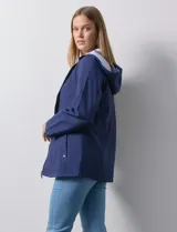 Campera impermeable azul con cierre central, bolsillos delanteros y lazo de ajuste en la cintura. Tiene avíos metálicos plateados y cierre oculto en la espalda para autoguardado.