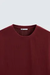 Camiseta de hombre color gris oscuro, de corte amplio, cuello redondo y manga corta.