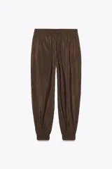 Pantalón de jogging color marrón, de tiro medio con cintura elástica ajustable con cordones, bolsillos delanteros y puños elásticos en los tobillos.
