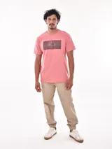 Remera color salmón con estampado rectangular con la palabra 'FEARLESS' en letras negras.