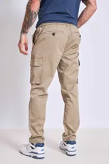 Pantalón cargo color beige, de corte recto, con bolsillos laterales con fuelle y cierre de solapa.
