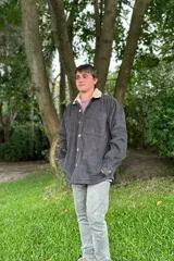 Campera de pana gris con interior de corderito color crema, cierre con botones a presión y bolsillos frontales.