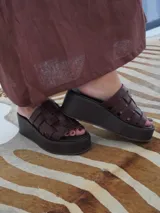 Sandalias negras de cuero con plataforma pareja y tiras de cuero tejidas en la parte superior.
