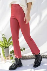 Pantalón de jean elastizado color ladrillo, de corte chupín y largo a la pantorrilla.