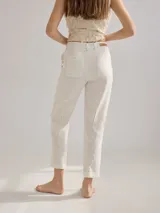 Pantalón cigarette color marrón claro, de lino, con bolsillos traseros y pinzas en la pierna trasera.