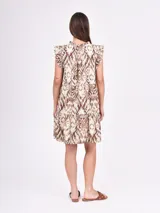 Vestido negro corto con volados en las mangas y escote en V con botones. El cuerpo es suelto con un corte a la altura de la cadera que genera un volante fruncido en la falda.