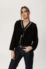 Camisa negra de estilo bohemio romántico, confeccionada en algodón con lino. Es un modelo de corte flojo y mangas estilo murciélago. Presenta volados en el escote y cierre frontal con botones.