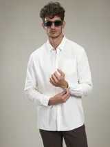 Camisa de manga larga color blanco con bolsillo en el pecho.