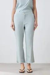 Pantalón celeste de lino, corte recto, con efecto desflecado en el ruedo.