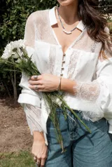 Camisa color beige con encaje en la parte delantera y en las mangas, de corte holgado.