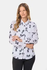 Blusa tipo camisa blanca de manga larga con botones nacarados ocultos.