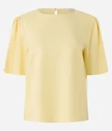 Blusa color amarillo claro, confeccionada en viscolino, con cuello redondo y mangas cortas abullonadas.