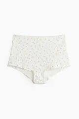 Bombacha tipo shortie de algodón color blanco con estampado de flores pequeñas. Tejido de punto pointelle con cintura alta, refuerzo interior y cobertura total en la parte de atrás.