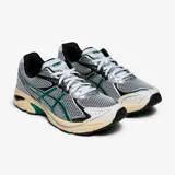 Zapatillas deportivas con diseño ligero en color gris y detalles en verde y negro, ideales para actividades deportivas.