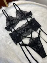 Conjunto de lencería negro de encaje, compuesto por un corpiño tipo bralette, una tanga de tira doble regulable, un portaligas desmontable y ligas regulables.