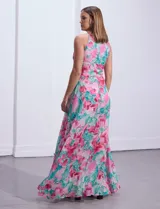 Vestido largo de gasa estampada con flores rosas y turquesas sobre fondo blanco. Tiene escote halter con ojal, cintura fruncida y falda con sobrecapa.