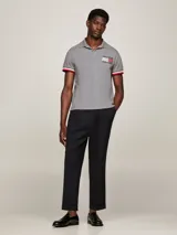 Chomba gris de corte slim confeccionada en algodón orgánico elástico, con cuello clásico, cartera de dos botones, logo de Tommy Hilfiger bordado en el pecho y ribetes distintivos en los puños.