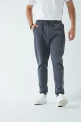 Pantalón deportivo clásico de felpa negro, con puños y bolsillo lateral con cierre.