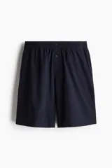 Conjunto de pijama corto de dos piezas. Remera negra de punto de algodón liviano con cuello redondo ribeteado acanalado, hombros caídos y bajo recto. Short negro en popelina de algodón con elástico revestido en la cintura, cierre de botón, bolsillos laterales y un bolsillo parche atrás.
